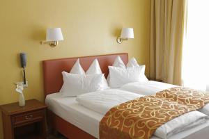 维也纳杜米兹尔酒店的配有白色枕头的床的酒店客房