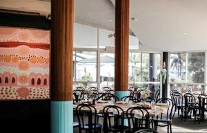 楠巴卡黑兹The Cubana Resort Nambucca Heads的用餐室设有桌椅和窗户。
