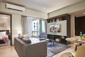 新加坡Somerset Bencoolen Singapore的带沙发的客厅和用餐室