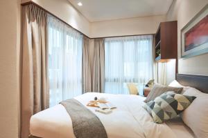 新加坡Somerset Bencoolen Singapore的一间设有大床和窗户的酒店客房