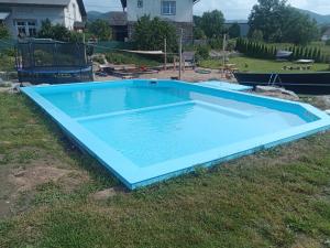 耶塞尼克Chata Tánička的草地上的大型蓝色游泳池