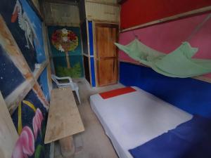 莫姆皮切Hostal Camping Sin Fronteras Mompiche的小房间设有一张床和吊床