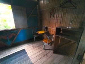 莫姆皮切Hostal Camping Sin Fronteras Mompiche的客房设有书桌和桌椅。
