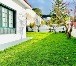 绍萨尔Vivienda Vacacional con vistas.的绿色草坪房子的院子