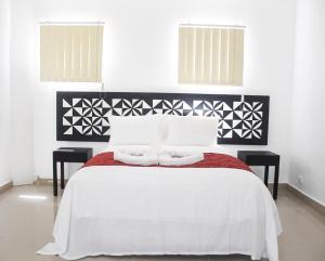 南迪"Best View Hotel & Apartments"的卧室配有白色的床和两张桌子