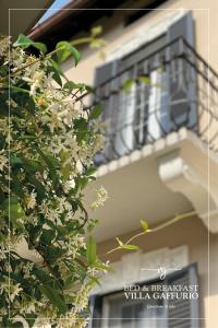 贝加莫Villa Gaffurio的带阳台的建筑和种有白色花卉的树