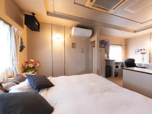 笛吹市Tabist Hotel Nizi Fuefuki Misaka的卧室配有一张白色大床