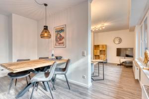 诺德奈Haus Kleemann E24的用餐室以及带木桌和椅子的客厅。