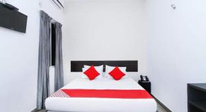 卡图纳耶克KINGS GATE Airport TRANSIT HOTEL的白色客房内的一张带红色枕头的床