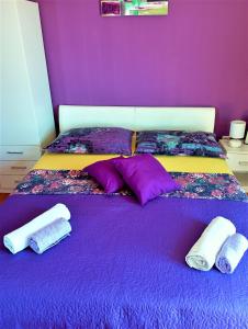 珀德垂那Penthouse apartment with a Great View的紫色卧室配有两张带紫色床单和枕头的床