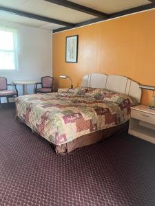 新荷兰Hollander Motel的卧室配有一张床和一张桌子及椅子