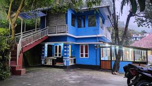 蒙纳Munnar happy holidayss的蓝色的房子,前面有楼梯