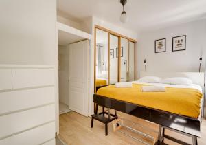 叙雷纳L'HYPERCENTRE de Suresnes的一间卧室配有一张黄色毯子床