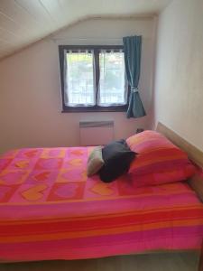 FullyAppartement Fully的一间卧室配有一张带五颜六色的被子的床和窗户
