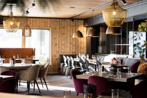耶卢Bardøla Fjelltun的餐厅配有桌椅和吊灯