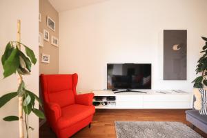 扎达尔Summer Breeze apartment的客厅配有红色椅子和电视