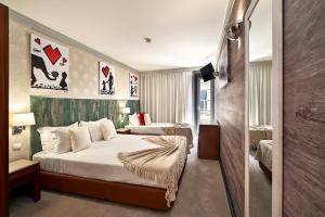 阿威罗Galeria Suite Hotel的酒店客房设有两张床和电视。