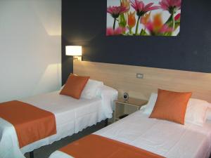 阿尔马索拉迈阿密旅馆的酒店客房设有两张床,墙上挂有绘画作品