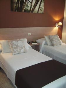 阿尔马索拉迈阿密旅馆的酒店的客房 - 带两张带枕头的床