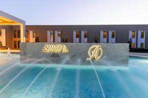 尼基季Ammoa Luxury Hotel & Spa Resort的游泳池前的标志