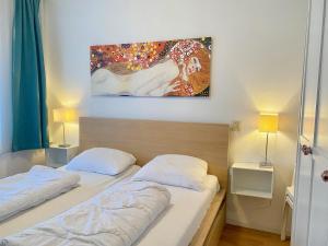 卡兰茨奥赫Badhotel 316的卧室内的两张床,墙上有绘画作品