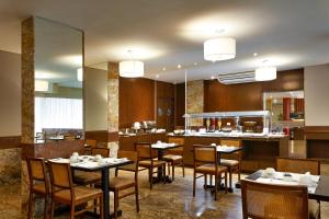 里约热内卢Windsor Palace Copacabana的一间带桌椅的餐厅和一间厨房