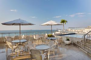 里约热内卢Windsor Palace Copacabana的一个带桌椅的庭院和一个游泳池
