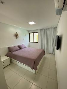 塔曼达雷Carneiros Beach Resort Flat的一间卧室配有一张床和一台电视