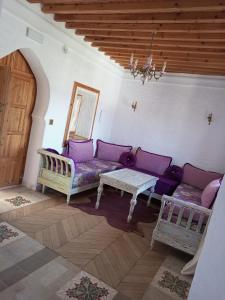 舍夫沙万RIAD LA SANTA的客厅配有紫色沙发和桌子