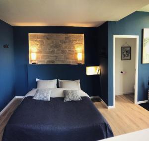 巴勒迪克La Guinguette de Michaux的蓝色卧室配有一张带两个枕头的大床