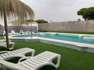 马塔拉斯卡尼亚斯Apartamentos Costa Luz的一个带躺椅和遮阳伞的游泳池