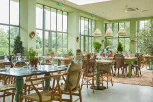 纽伯里The Retreat, Elcot Park的用餐室设有桌椅和窗户。