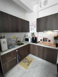 哥打巴鲁Prestige Troika Kota Bharu的厨房配有棕色橱柜和地板上的标志