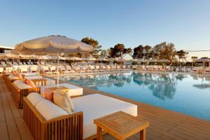 圣安东尼奥TRS Ibiza Hotel -All Inclusive Adults Only的毗邻度假酒店的带桌椅的游泳池