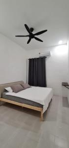 丰盛港Voon 4 bedroom homestay Mersing的一间卧室配有一张带吊扇的床