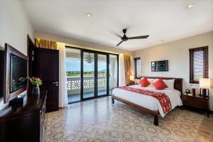 会安RiverTown Hoi An Resort & Spa的一间带大床的卧室和一个阳台