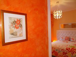索非亚橙花1号公寓的一间卧室配有橙色墙壁、一张床和一张图片
