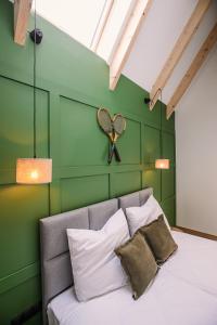 ŻegocinaApartamenty Na Potokach的一间卧室设有绿色的墙壁和一张带枕头的床