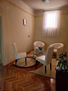 毛科Szent István Wellness Panzió的客厅配有椅子、桌子和窗户