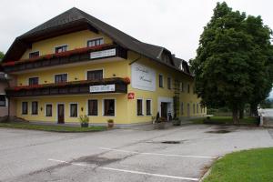 AigelsbachLandgasthof Kammerhof的前面有树的黄色建筑