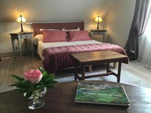 JouyLa Meunière的一间卧室配有一张床和一张桌子及一本书