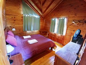 普埃洛湖Cabañas El Refugio de Puelo的小木屋内一间卧室,配有一张床