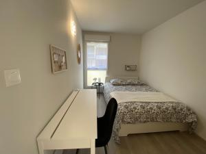 布吕兹Appartement familial tout confort - 3 chambres, grande terrasse privative - Vert Buisson - Bruz的一间小卧室,配有一张床和一张书桌