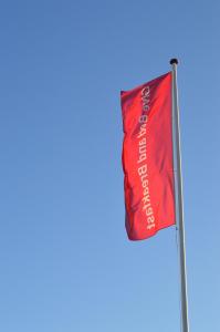 吉弗基弗经济型酒店（客房&早餐）的蓝天的柱子上的红旗