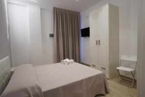 玛格丽塔萨沃亚Punta Pagliaia rooms的卧室配有白色的床和白色橱柜