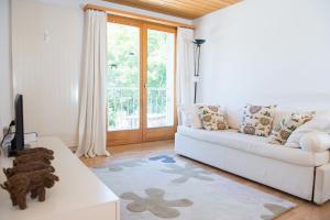 库尔瓦尔登Zwei Zimmer Ferienwohnung Rabiusa Churwalden的客厅配有白色沙发和窗户
