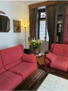 科英布拉阿连特亚纳住宅酒店的客厅配有红色的沙发和两把椅子