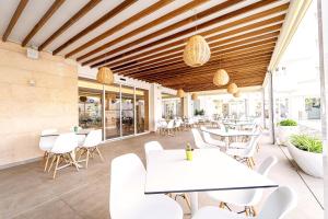 萨科马Ibersol Siurell的一间设有白色桌子和白色椅子的餐厅