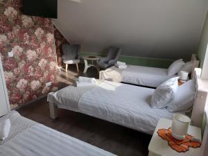 IisakuTamme Teemaja的酒店客房,配有两张床和两把椅子
