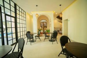 瓜达拉哈拉Hotel Dex Tlaquepaque的一间在房间内配有桌椅的餐厅